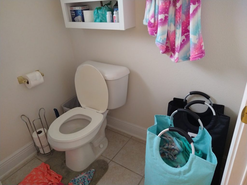 My daughter's bathroom - toilet, hamper, clothes on floor