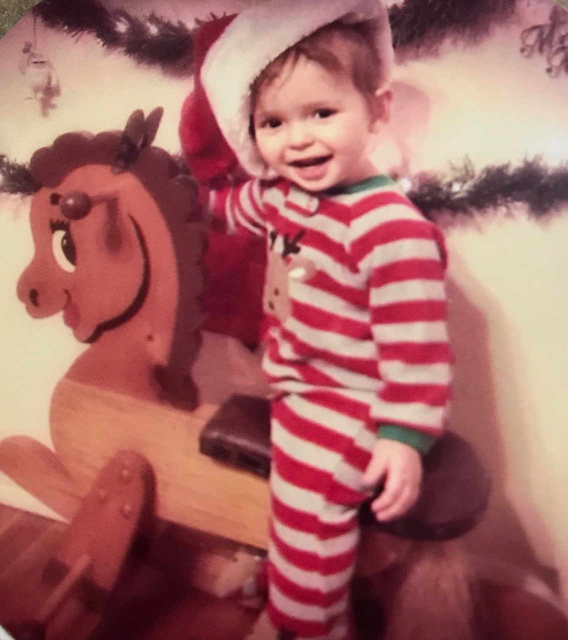 boy in Christmas pajamas on a hobby horse