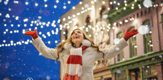 woman enjoying Christmas lights downtown