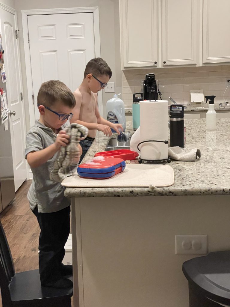 The power of praise; two young boys doing the dishes