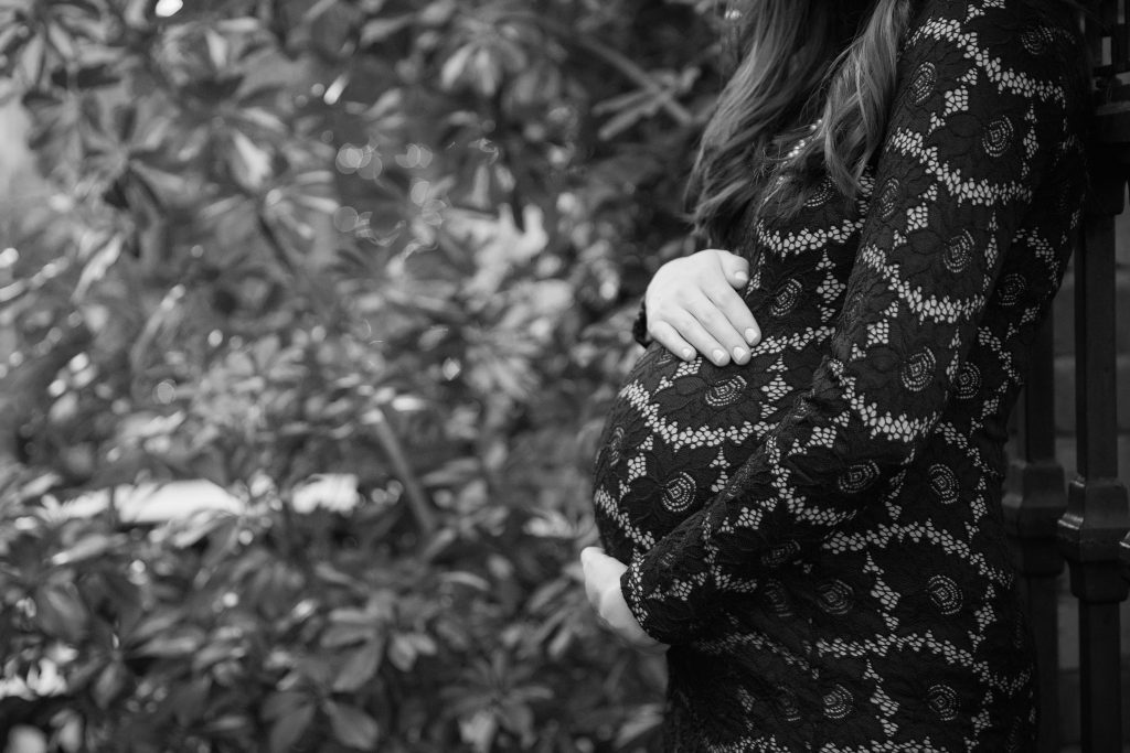 Losing the weight; an expectant mother cradling her belly