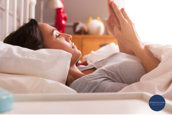 Woman lying in bed and scrolling Instagram