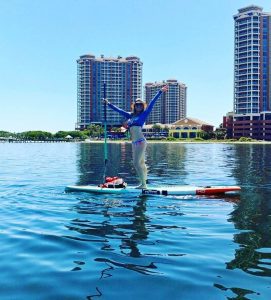 a woman on the water on her stand up paddle board