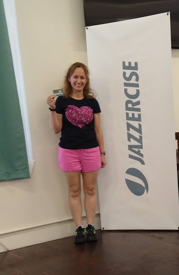 Mom posing in workout gear next to Jazzercise sign