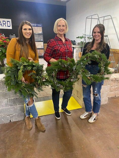Three women holding wreaths