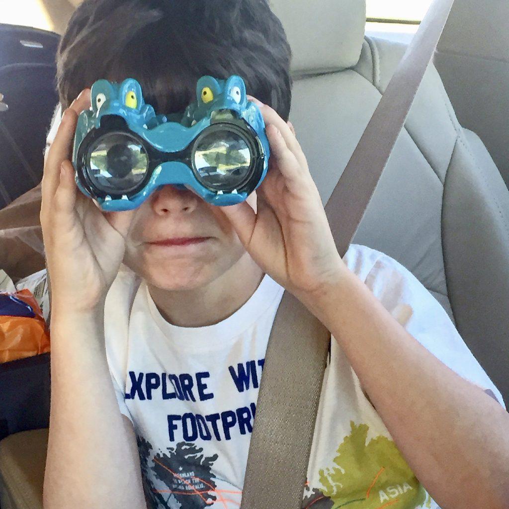 a young boy looking through binoculars