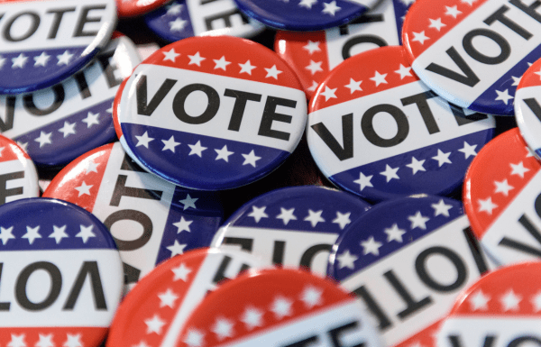 A collection of red, white and blue campaign style buttons that say "vote"