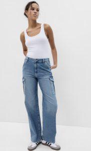 a woman wearing wide-leg jeans and a white tank top