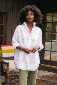 an African American woman wearing a white button-down shirt with olive green pants