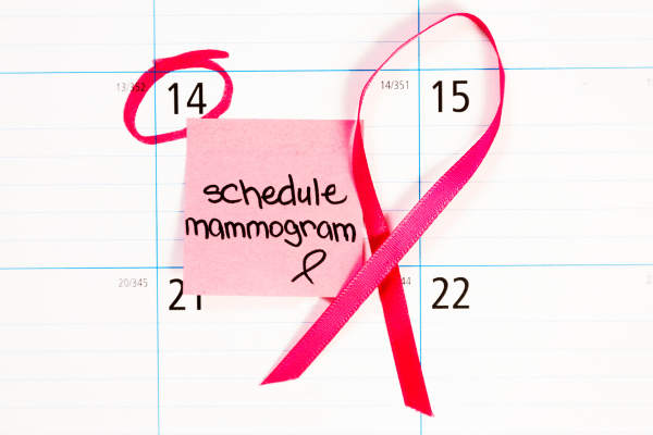 a calendar page with a pink ribbon and pink post-it that says "schedule mammogram"