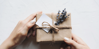 a gift box wrapped in brown paper with string and a sprig of fresh lavender tied in.