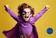 young boy in a superhero costume, striking a triumphant pose with a wide grin