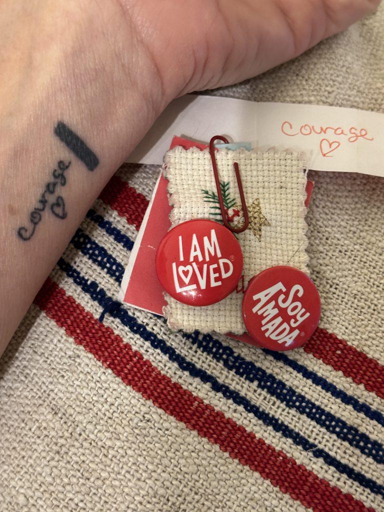 A small bundle of fabric with the words "I am loved" pinned to it.