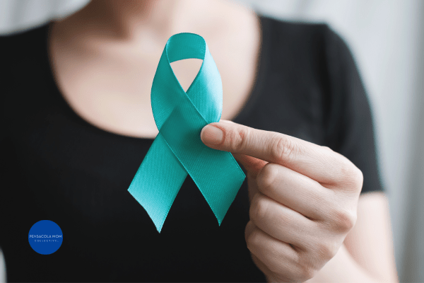 a woman holding a teal ribbon for cervical cancer awareness month
