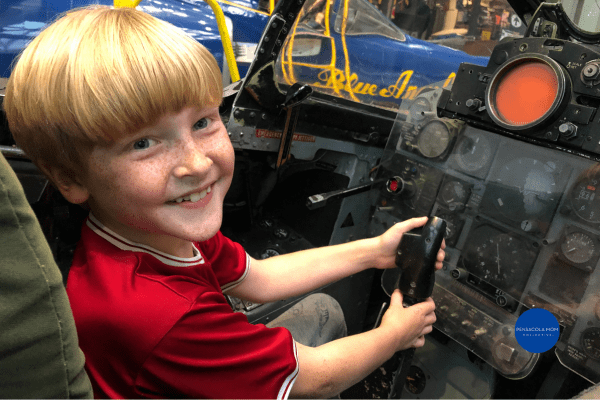 A young boy sitting inside an aircraft at the Naval Aviation Museum
