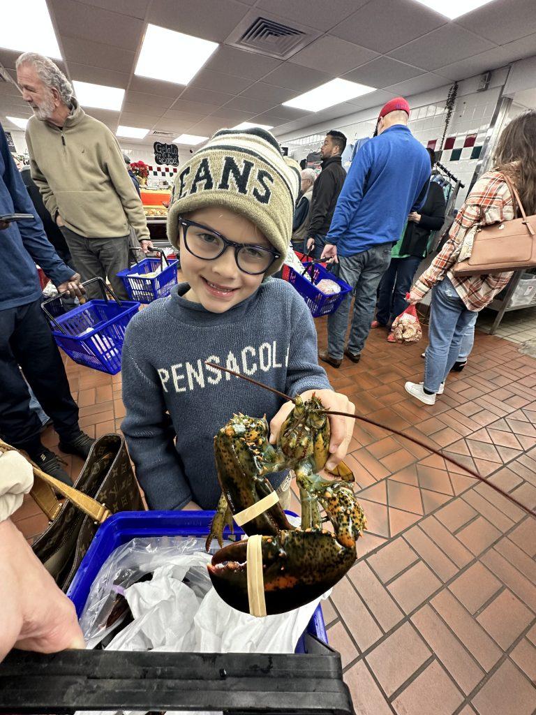 A young boy holding a lobster at Joe Patti's fish market in Pensacola