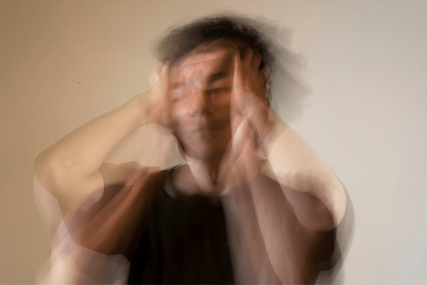 blurry image of a man holding his head