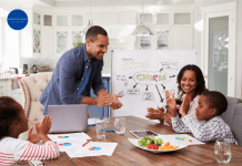 A family sitting around the kitchen table discussing goals, plans and chores.